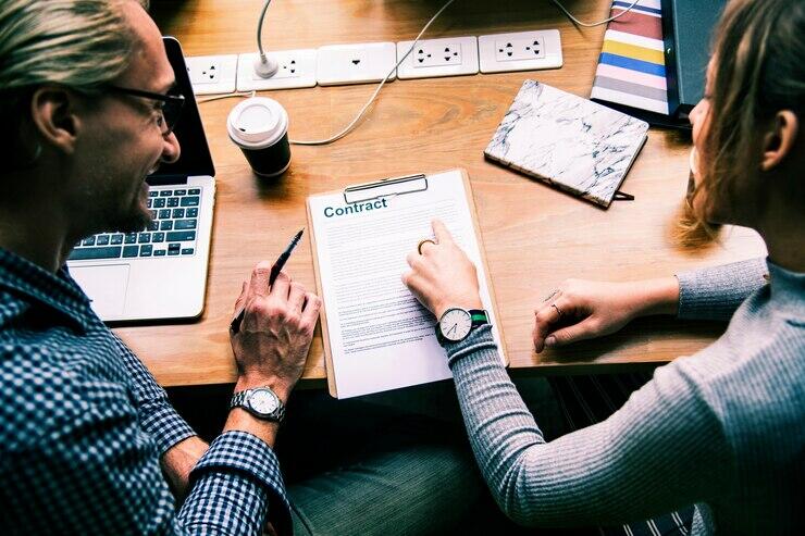 Two people review a NSW off-the-plan contract. "Contract" is visible.
