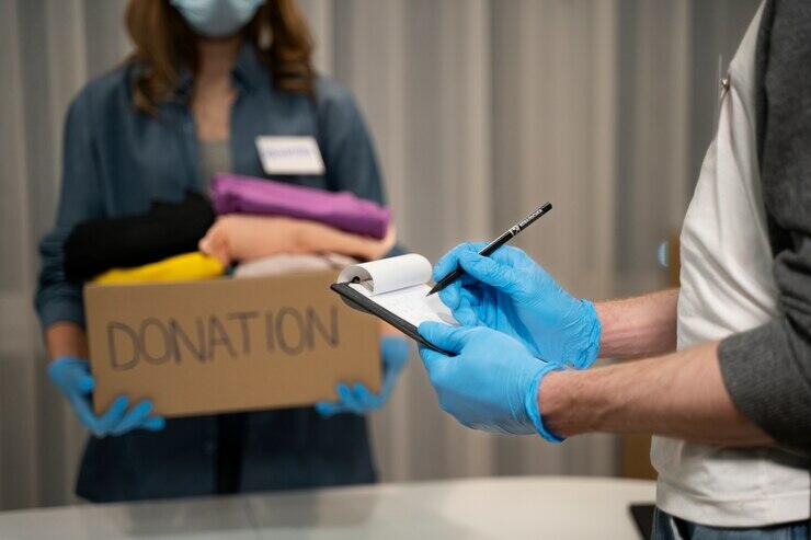 Volunteer recording donation details, ensuring ACNC compliance for charity board processes. "Donation" box visible.