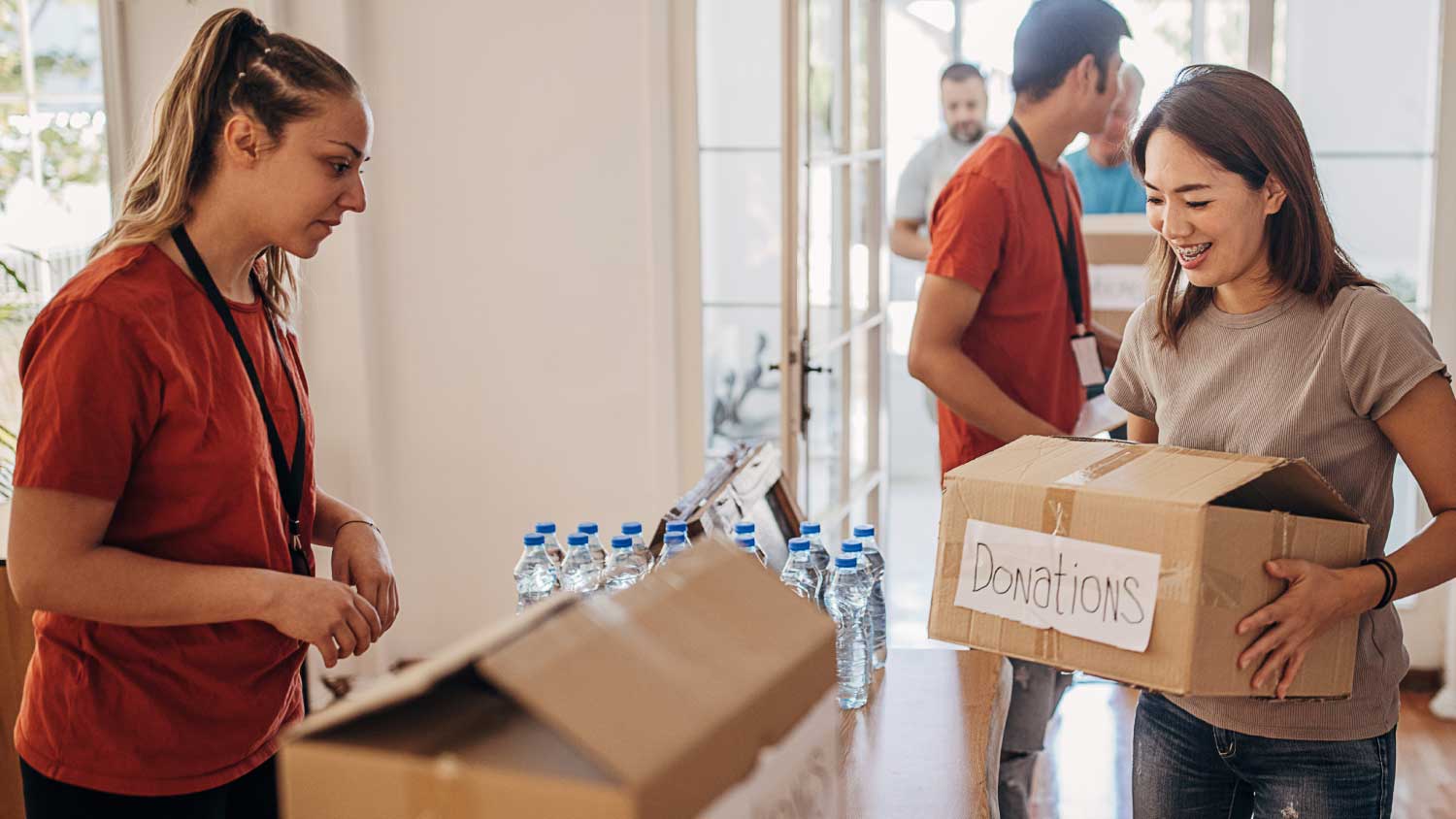Volunteers sorting donations at a not-for-profit organization in Australia. Box labeled "Donations.
