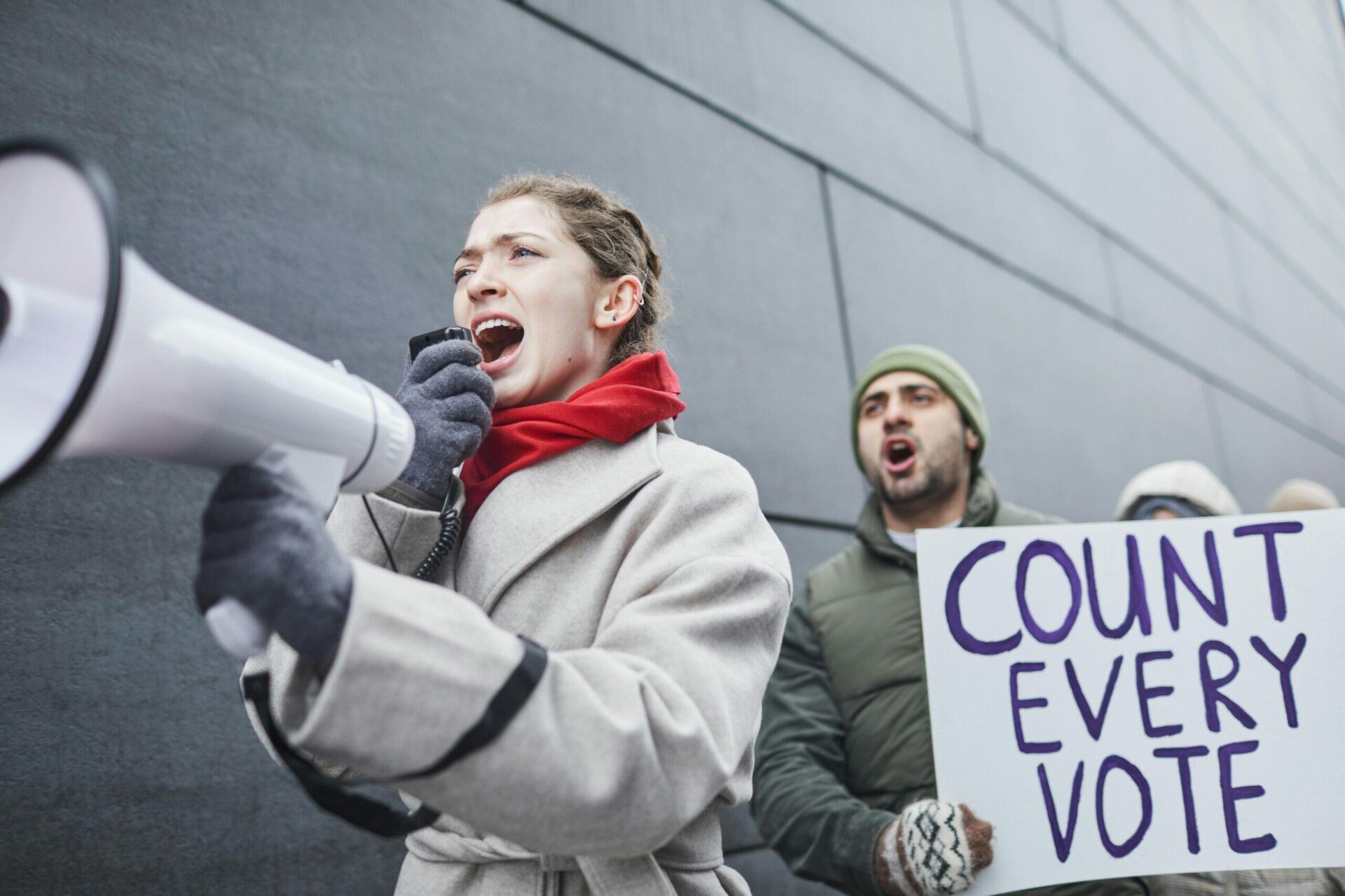 Protestors holding a "Count Every Vote" sign, advocating for fair elections.