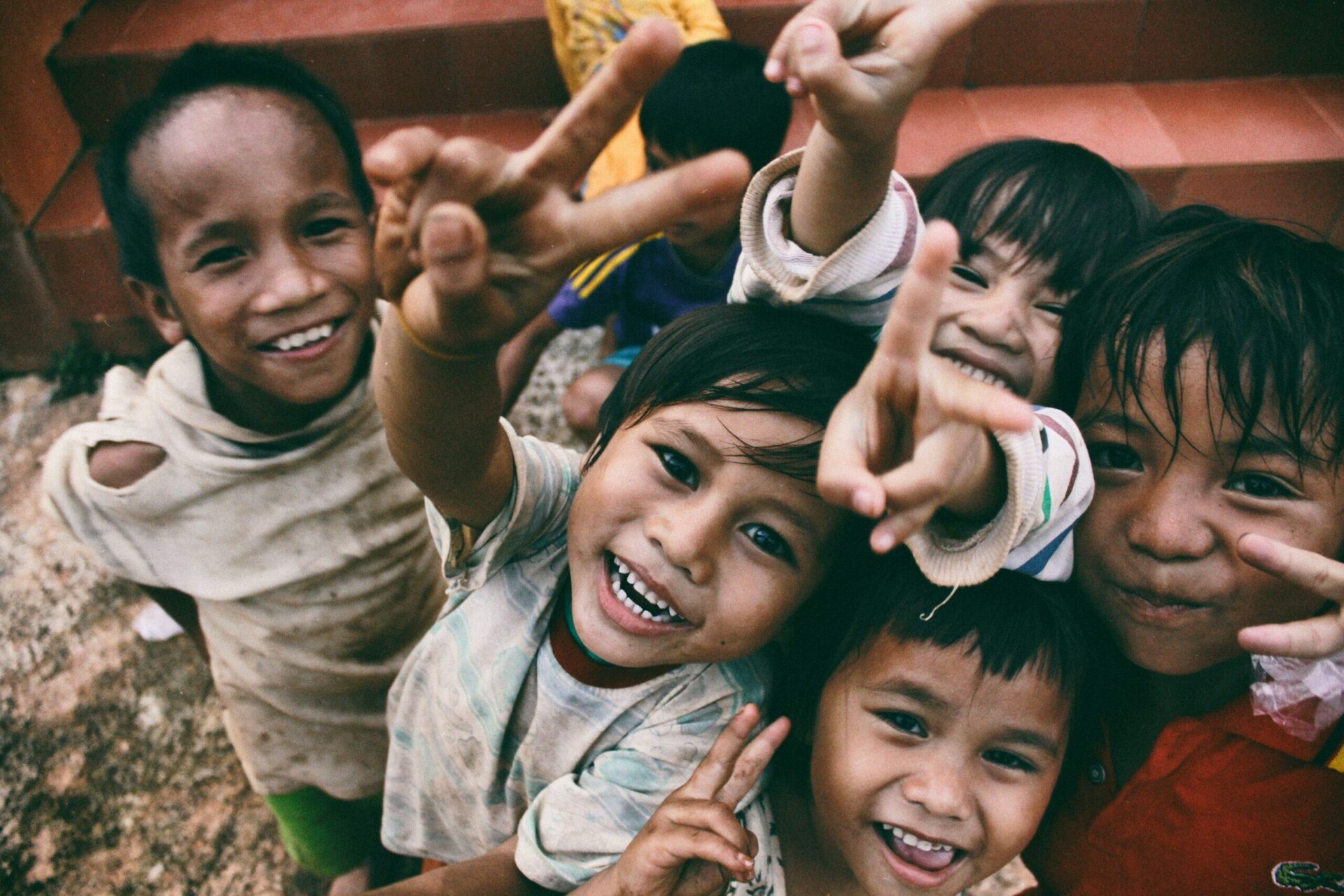 Happy children flashing peace signs.