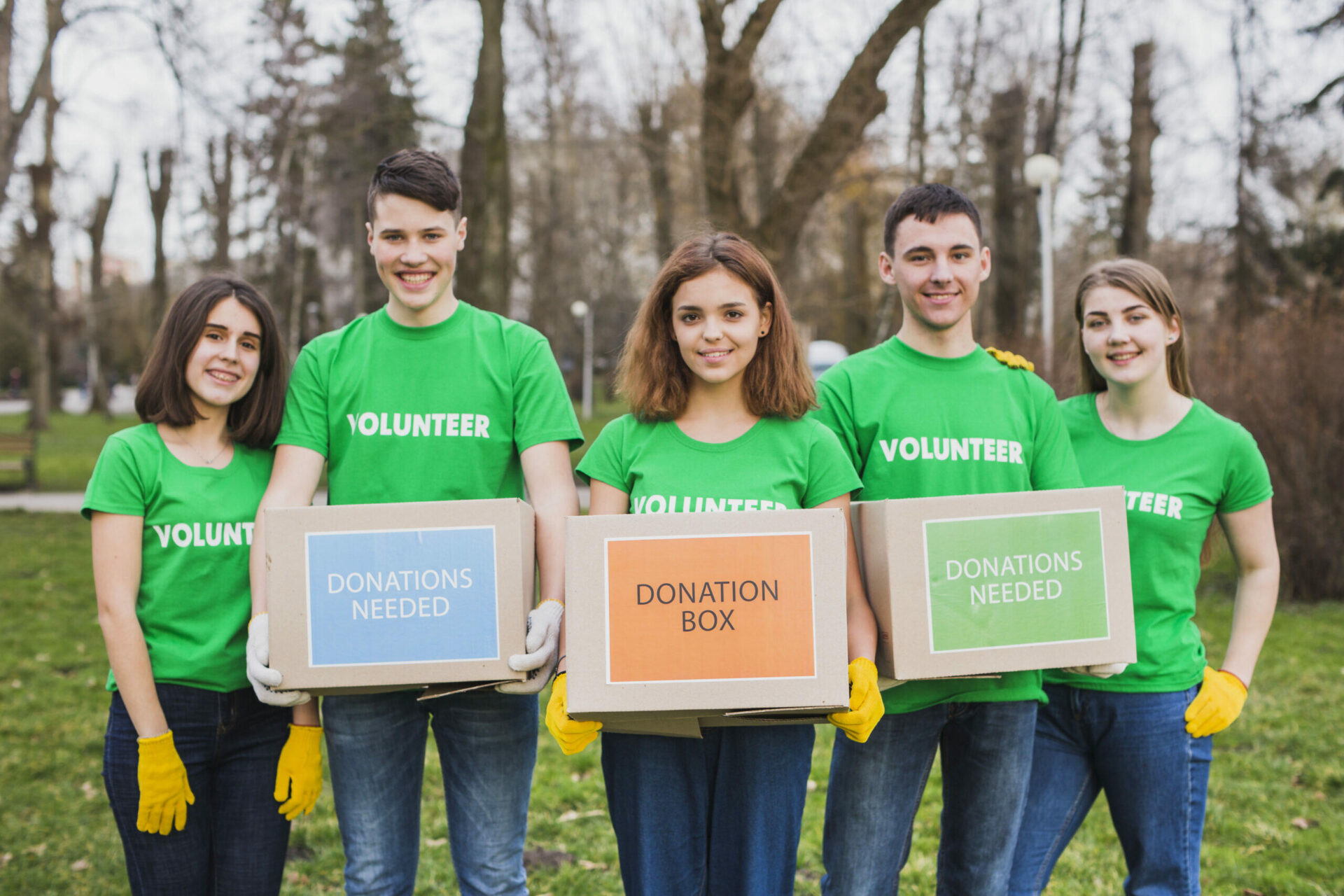 Five young volunteers holding donation boxes. "Donations Needed" and "Donation Box" are visible.