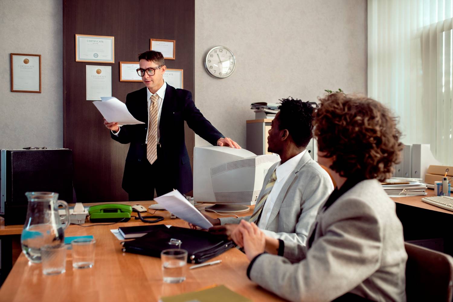 Office meeting with a man presenting documents, relating to ACNC investigations.