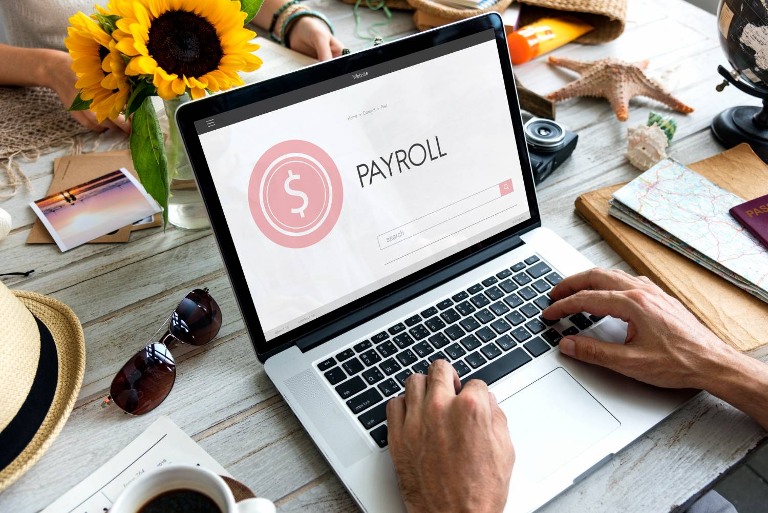 Laptop displaying a payroll website with dollar sign icon.