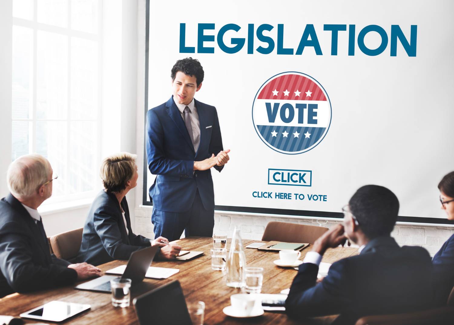 Presenter discussing legislation and voting in a meeting. "Vote" and "Click here to vote" text included.