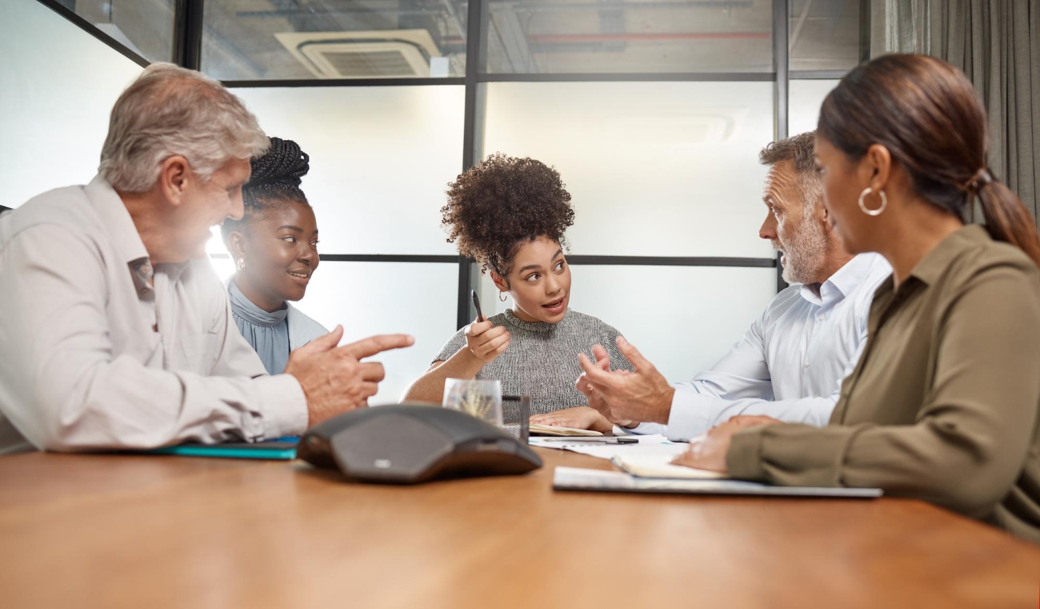 Diverse team in a meeting, discussing conflict resolution strategies for nonprofit organizations.