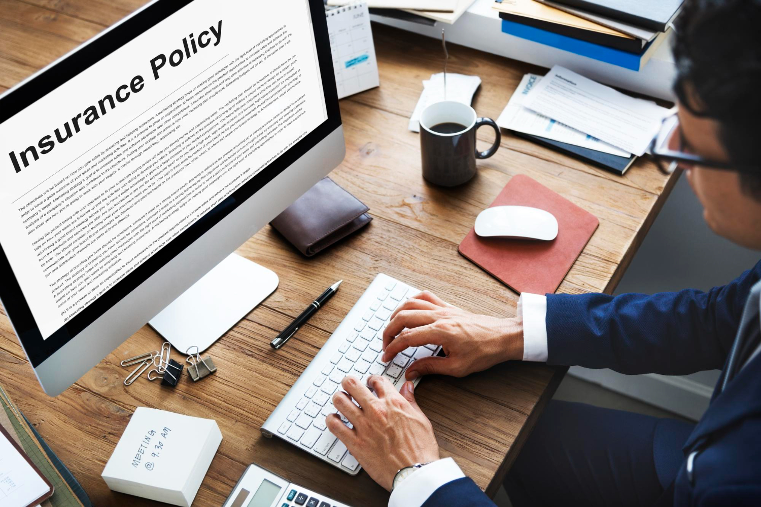 Man reviews insurance policy on computer, managing charity risks and costs