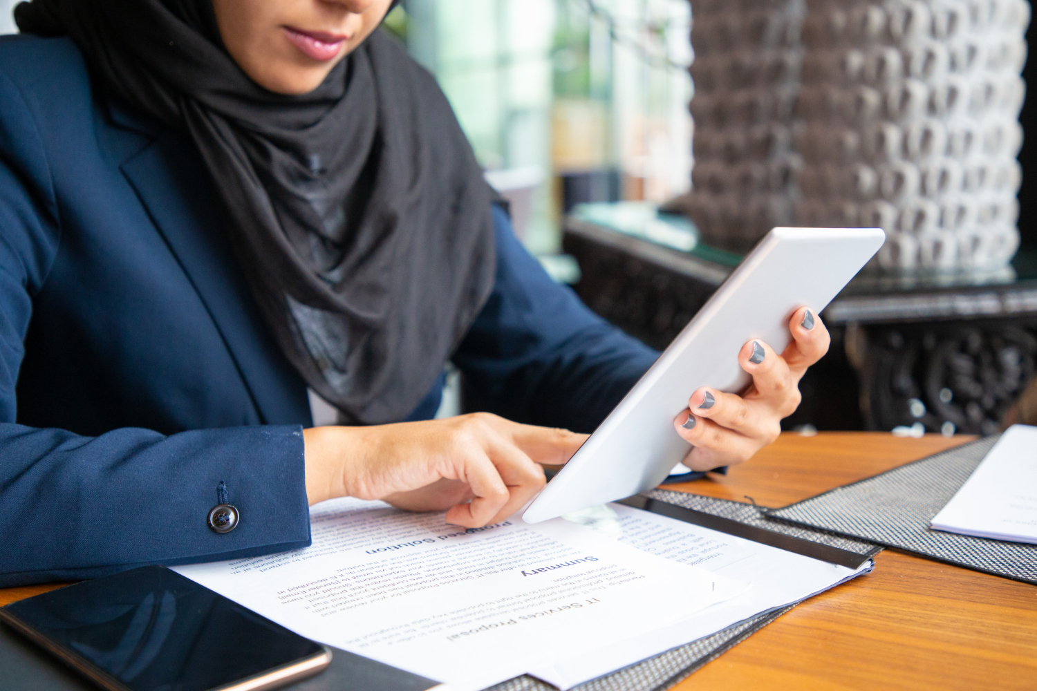 Woman in hijab reviewing Islamic will documents on a tablet for probate in NSW.