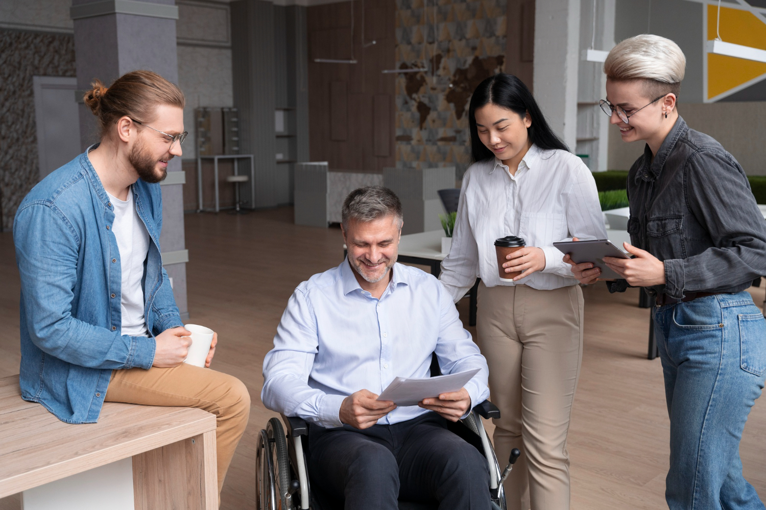 Diverse team discussing documents, including a person in a wheelchair.