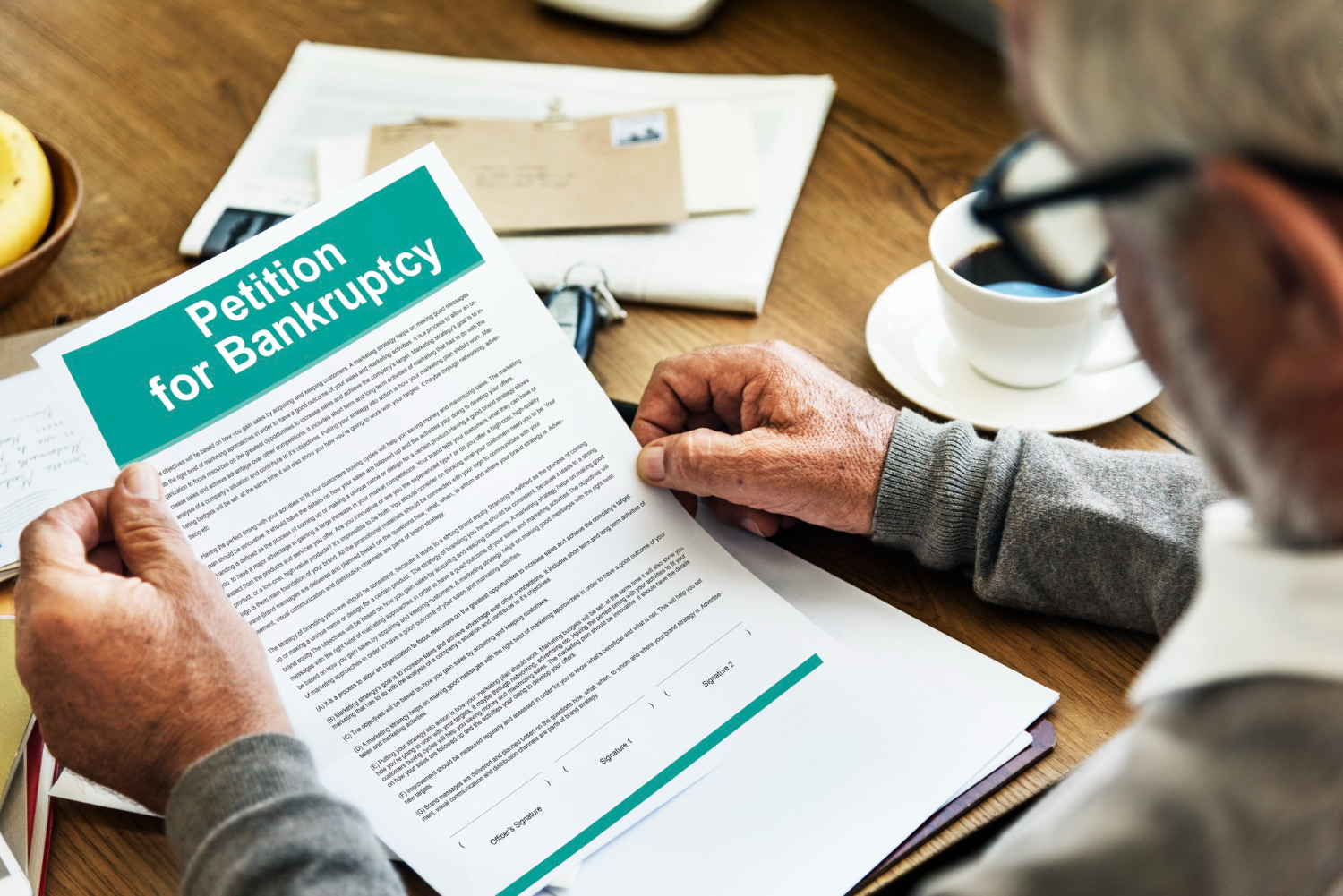Man reviews a Petition for Bankruptcy document, relevant to estate administration for a bankrupt deceased person.