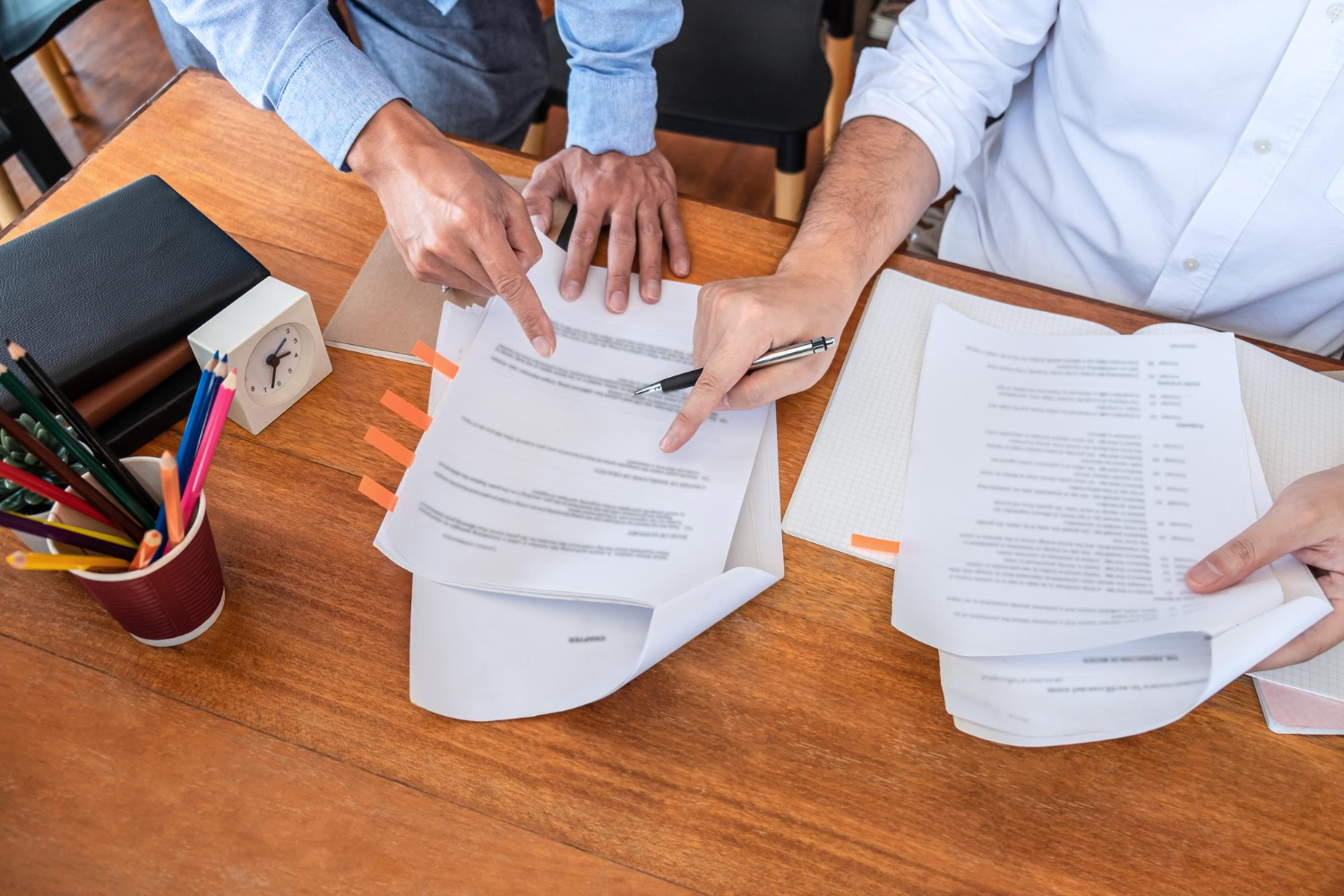 Two people reviewing documents, one pointing to text, discussing pre-grant powers in NSW.