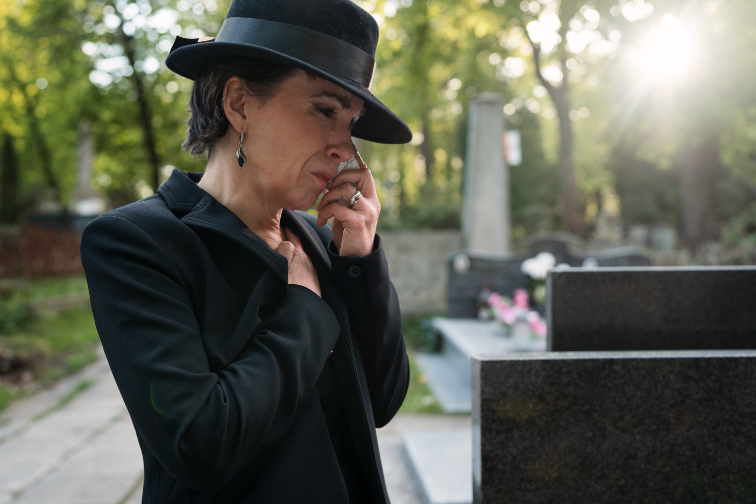 Woman in black hat at a funeral, reflecting on estate administration in NSW.