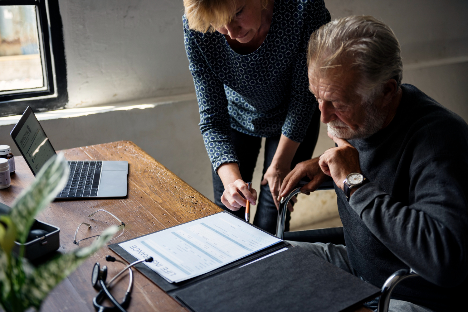 Elderly man and woman reviewing life insurance document, NSW probate timeline