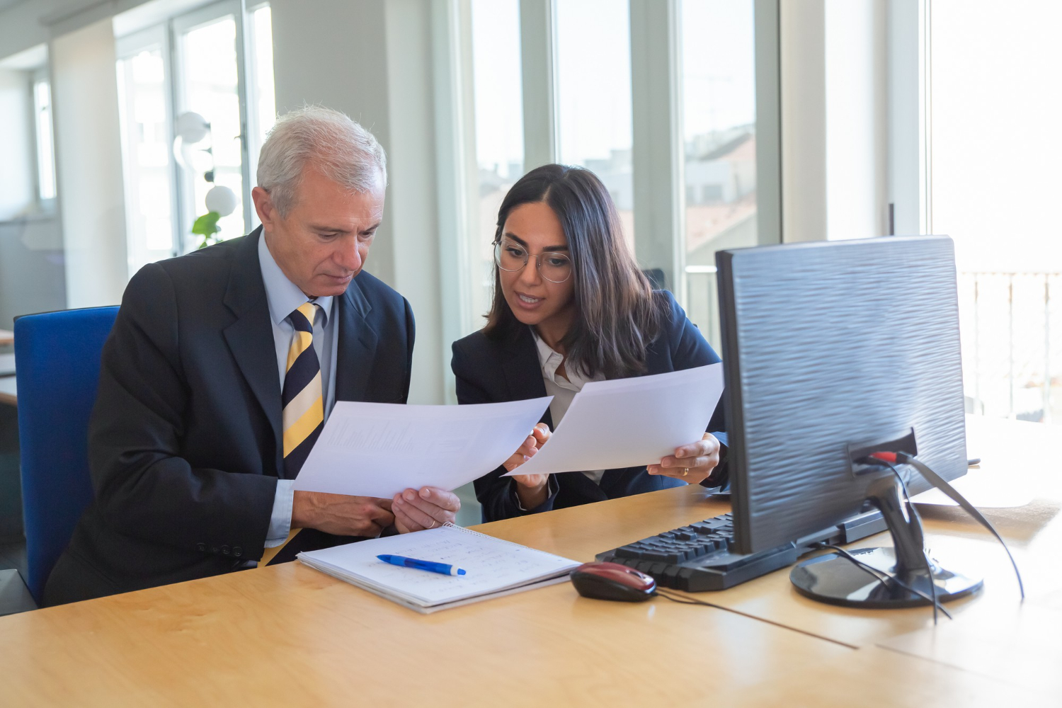 Business professionals reviewing documents at a desk, discussing tax and CGT risks in Australia.