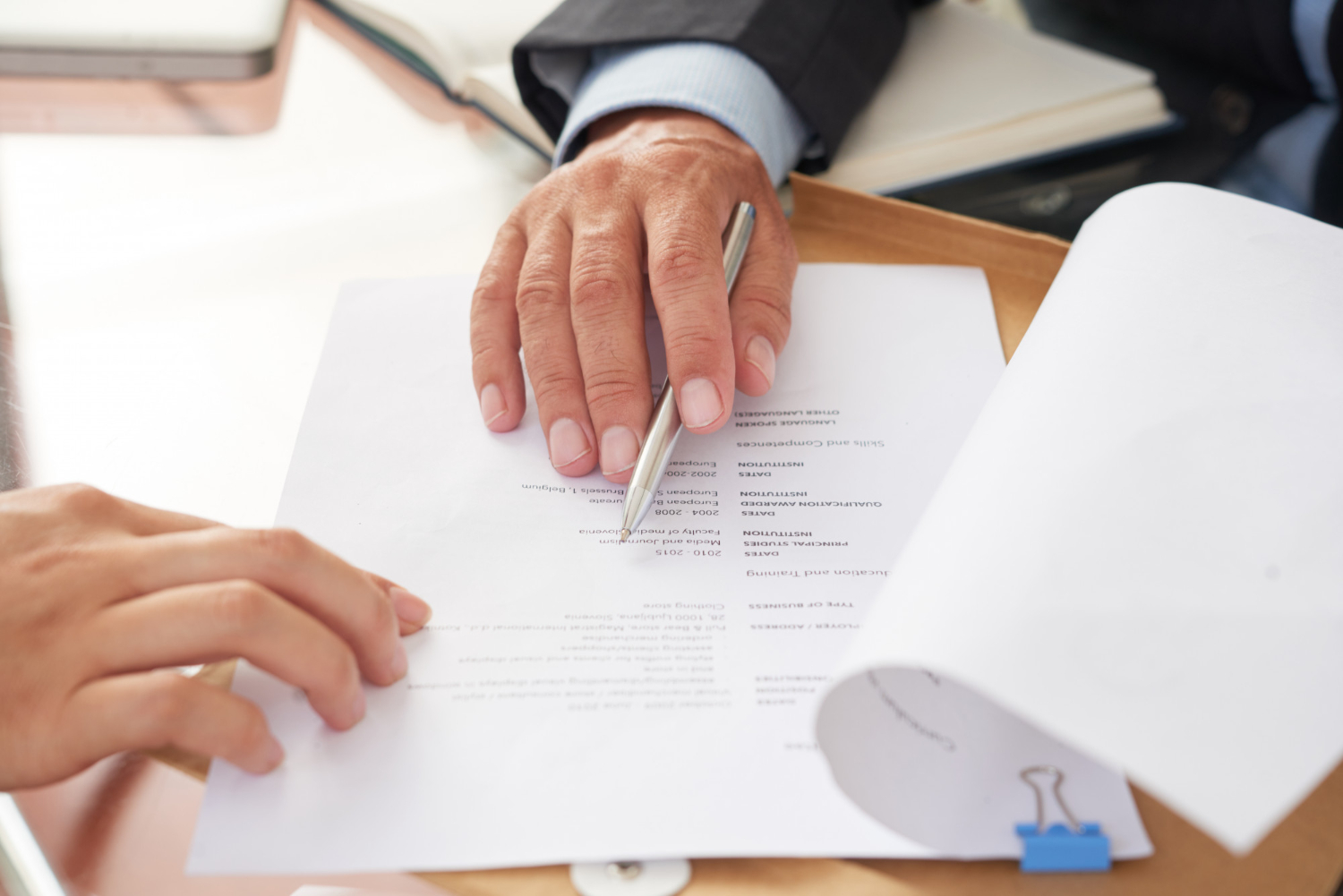 Hands reviewing legal documents, possibly for probate or administration in Australia.