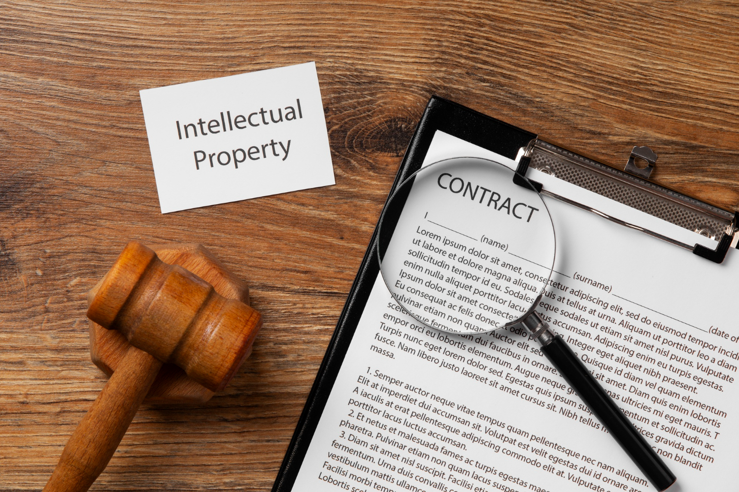 Gavel, magnifying glass over contract, and "Intellectual Property" card