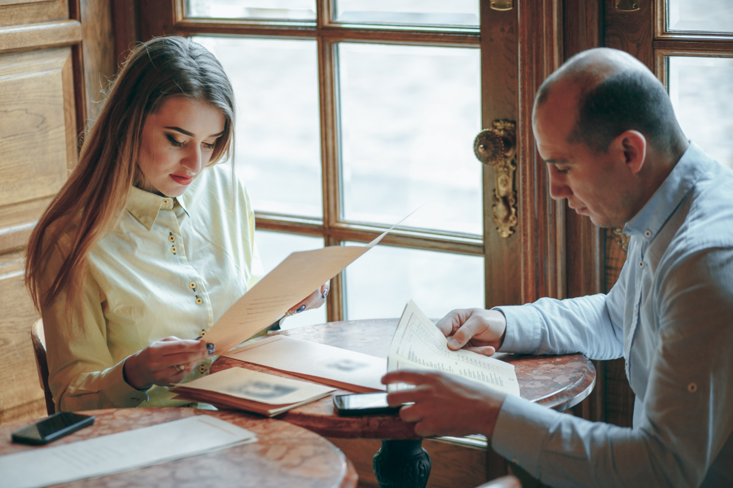 Couple reviewing documents at a table, possibly discussing legal matters.