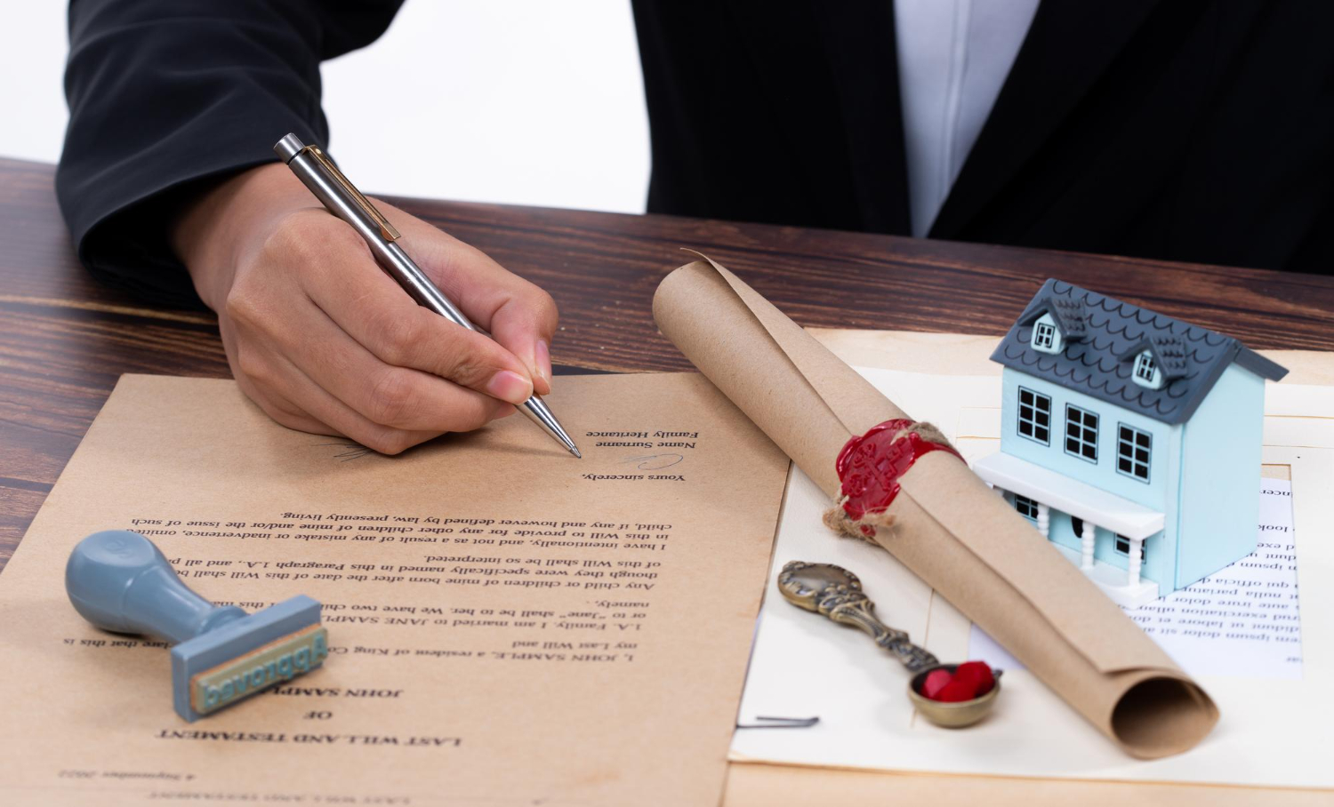 Person signing a will with a stamp and model house, estate administration in NSW
